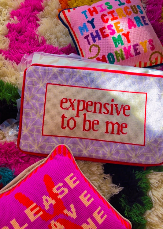 Three colorful pillows with text on a textured surface