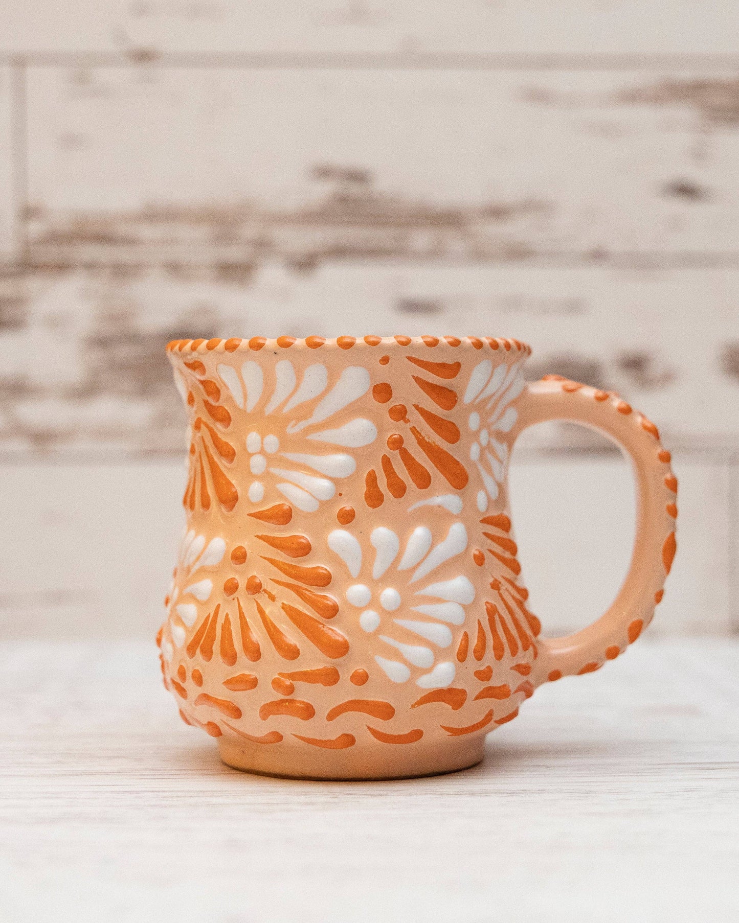 Ceramic mug with floral pattern on a wooden surface