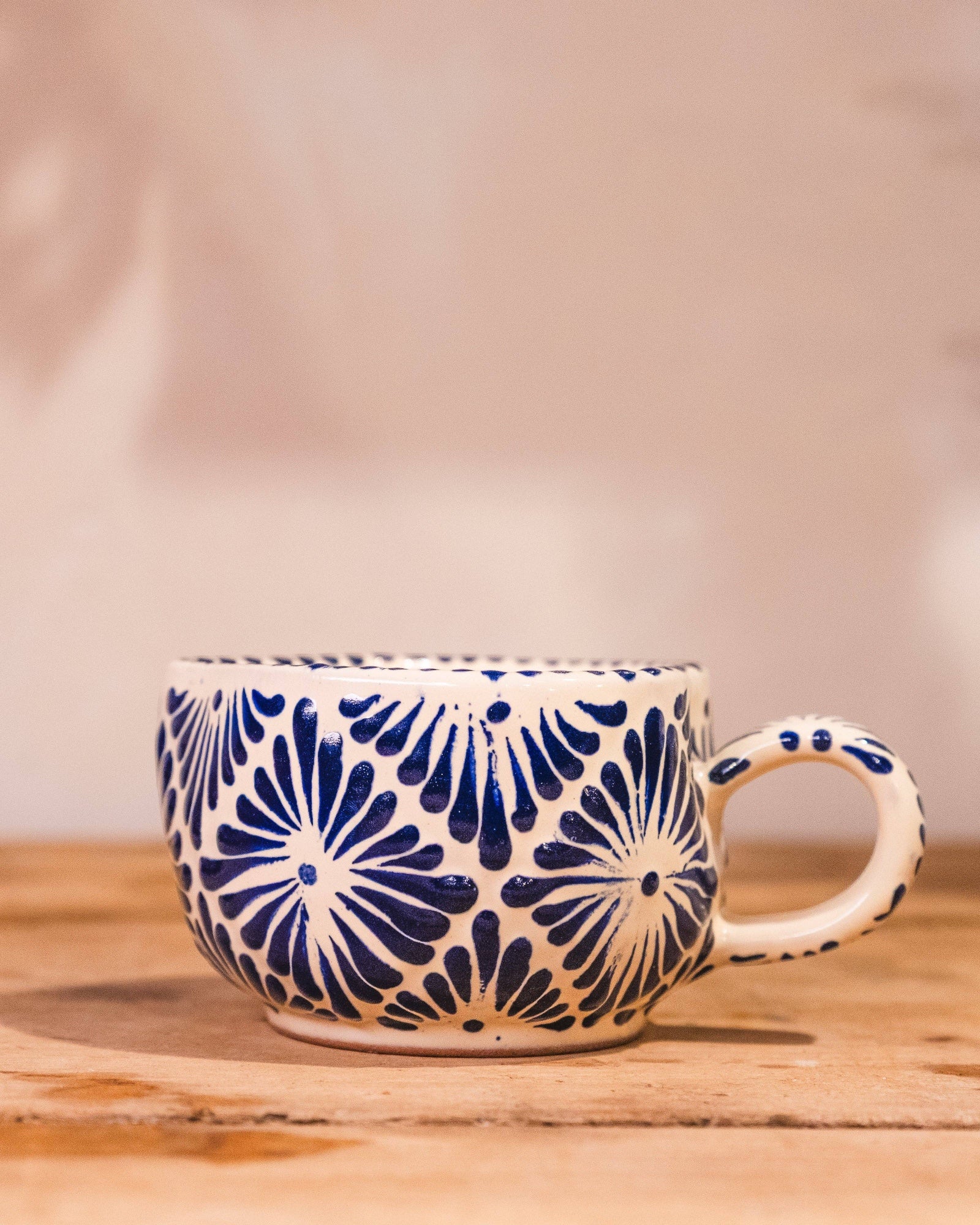Ceramic mug with blue floral pattern on a wooden surface